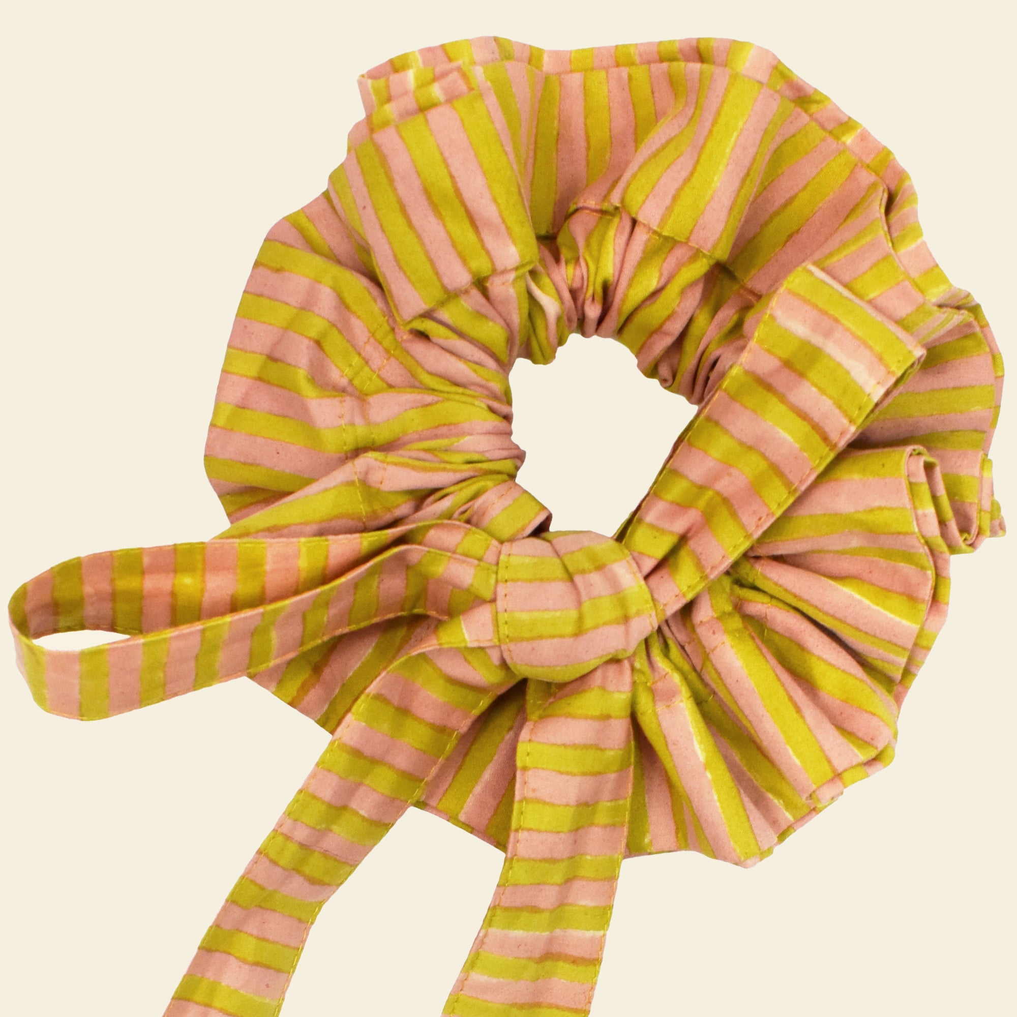 Closeup of cotton tie collar/scrunchie with ribbons printed with yellow and pink striped pattern