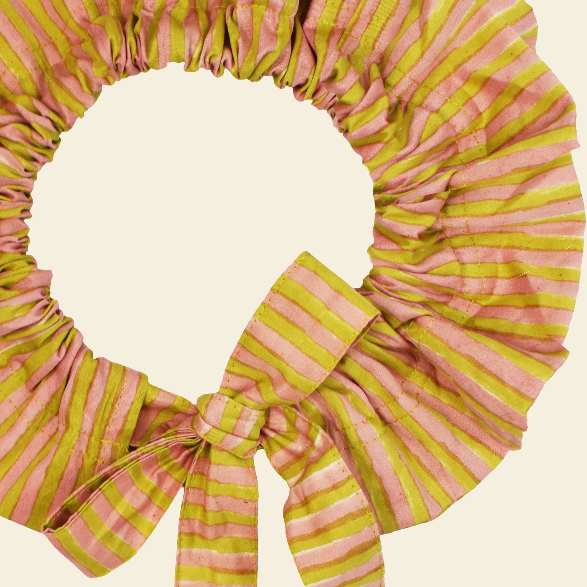 Closeup of cotton tie collar/scrunchie with ribbons printed with yellow and pink striped pattern