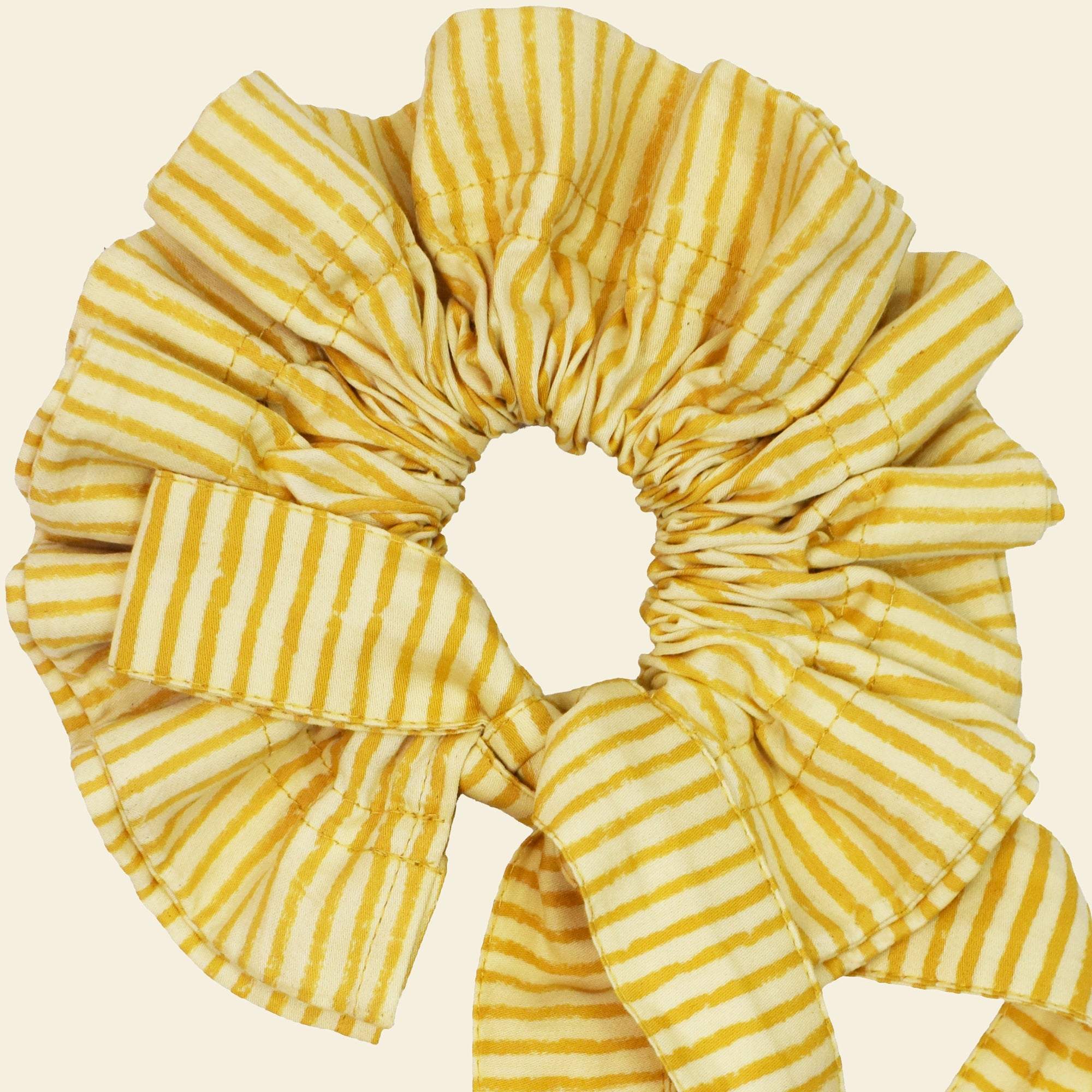 Closeup of cotton tie collar/scrunchie with ribbons printed with yellow striped pattern