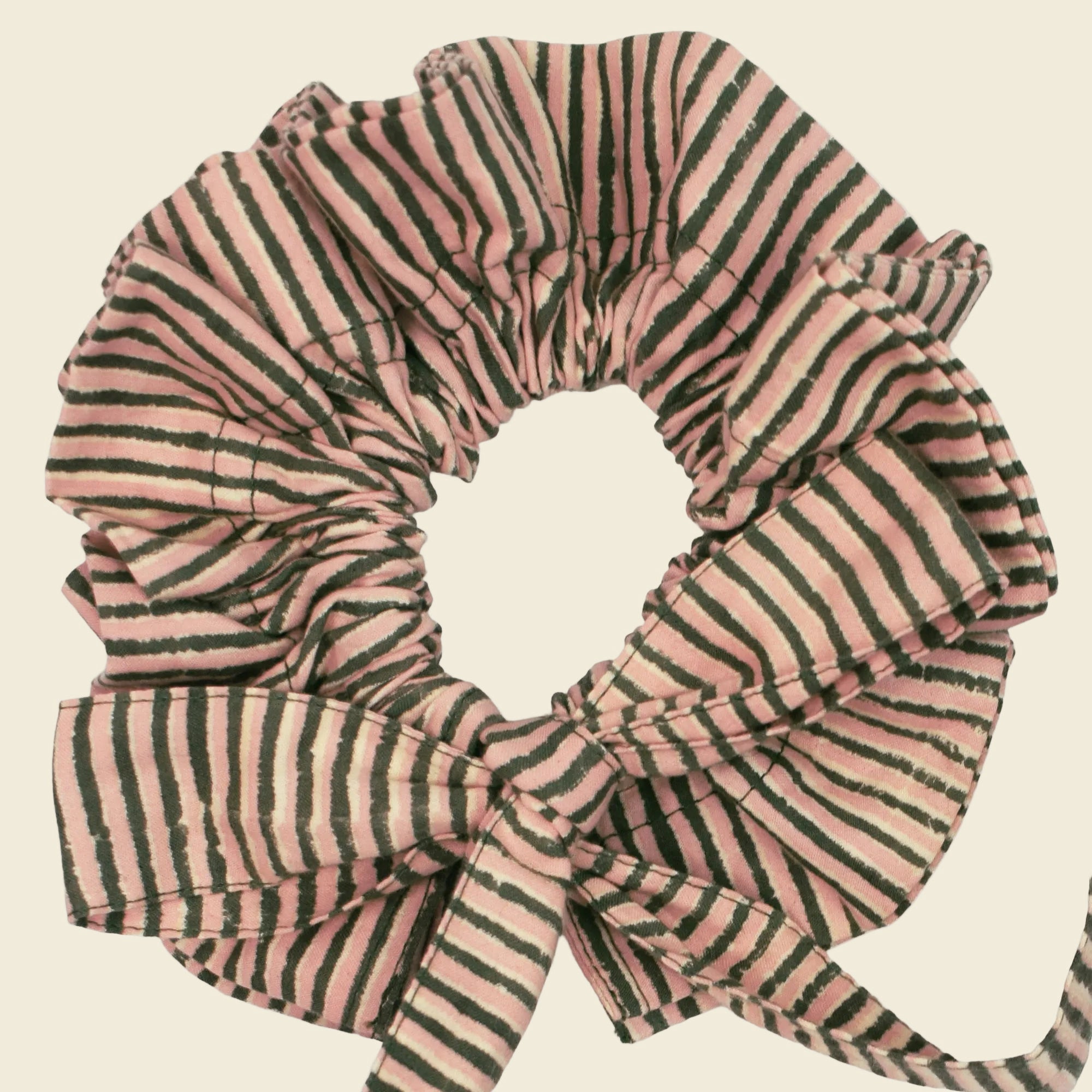Closeup of cotton tie collar/scrunchie with ribbons printed with green and pink striped pattern
