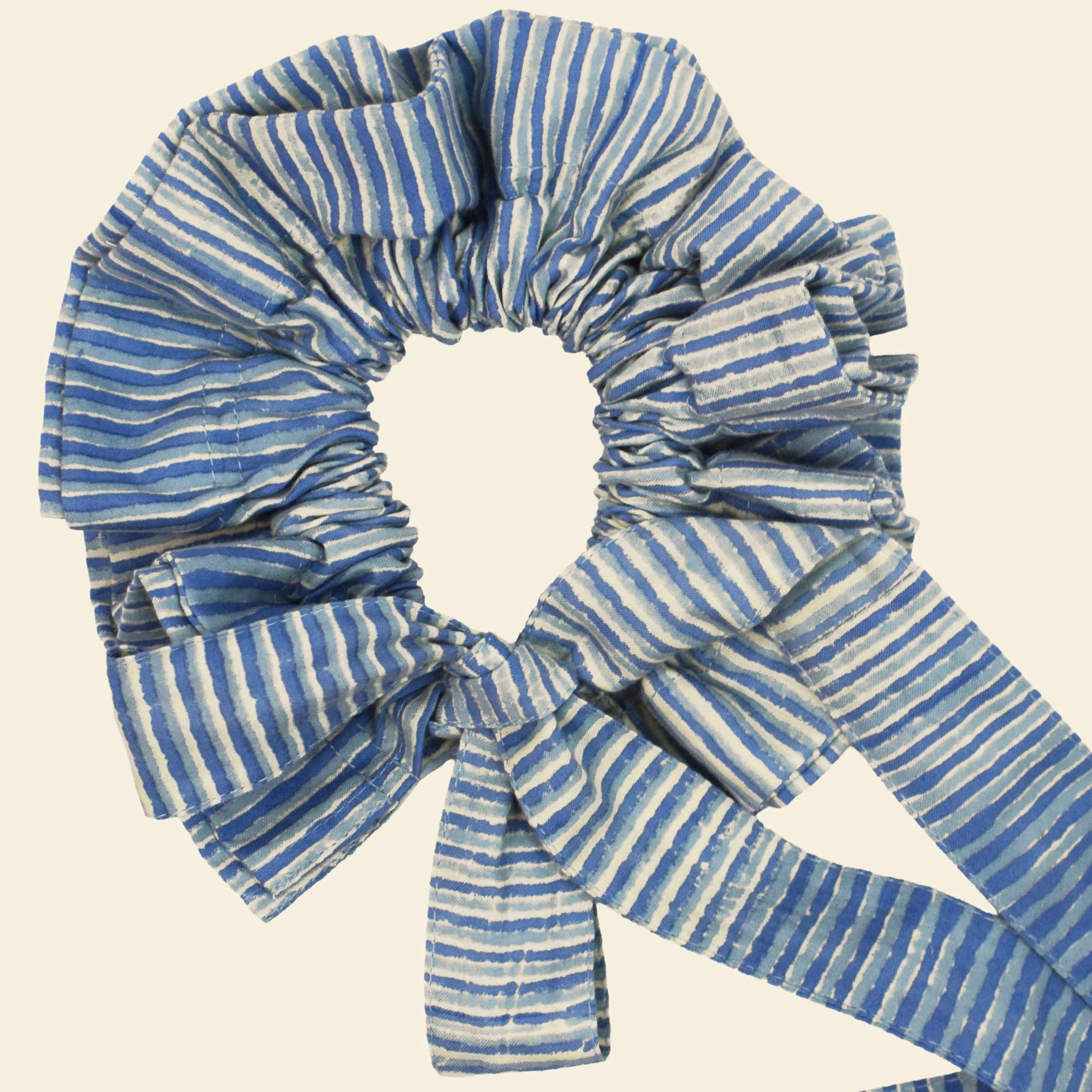 Closeup of cotton tie collar/scrunchie with ribbons printed with blue striped pattern