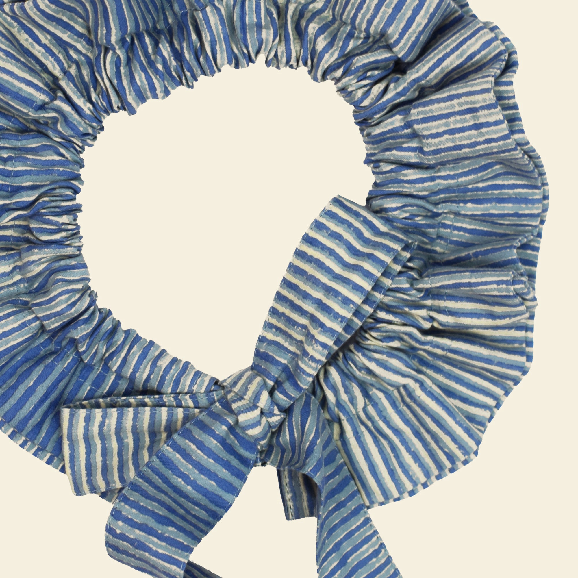 Closeup of cotton tie collar/scrunchie with ribbons printed with blue striped pattern