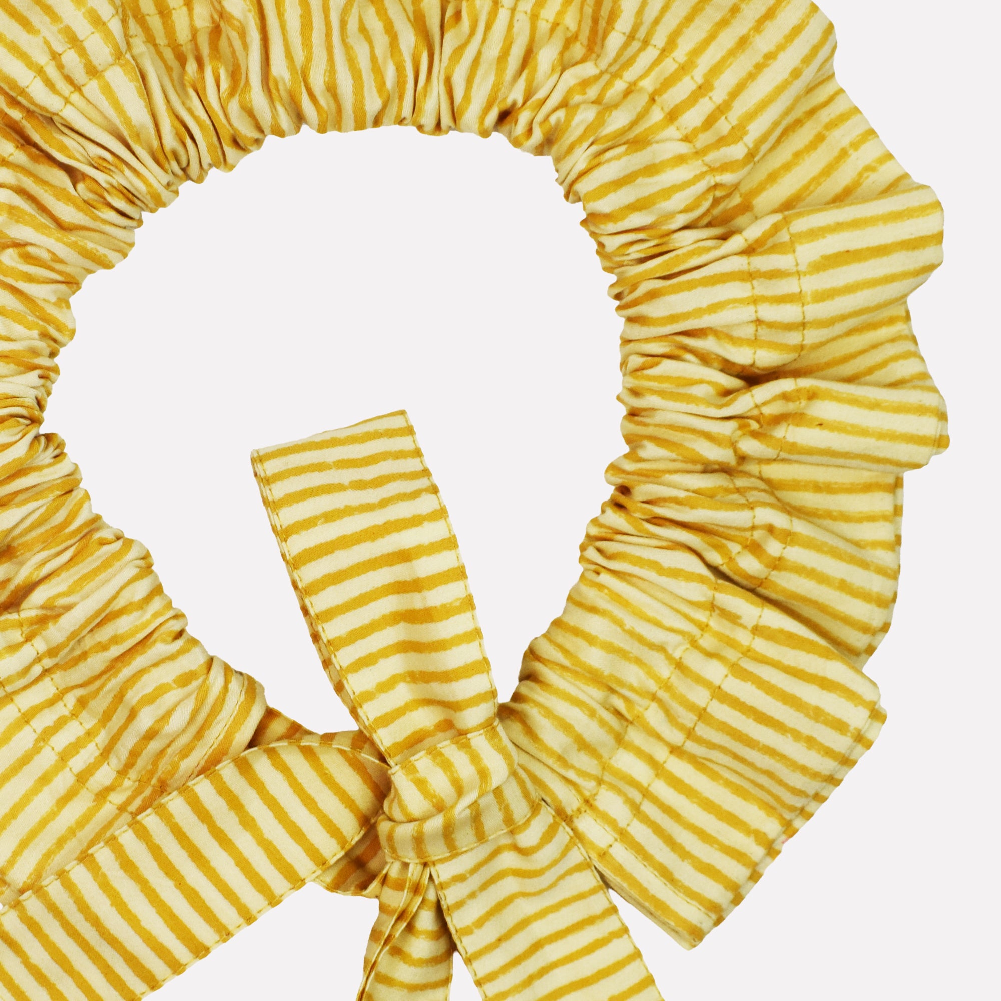Closeup of cotton tie collar/scrunchie with ribbons printed with yellow striped pattern