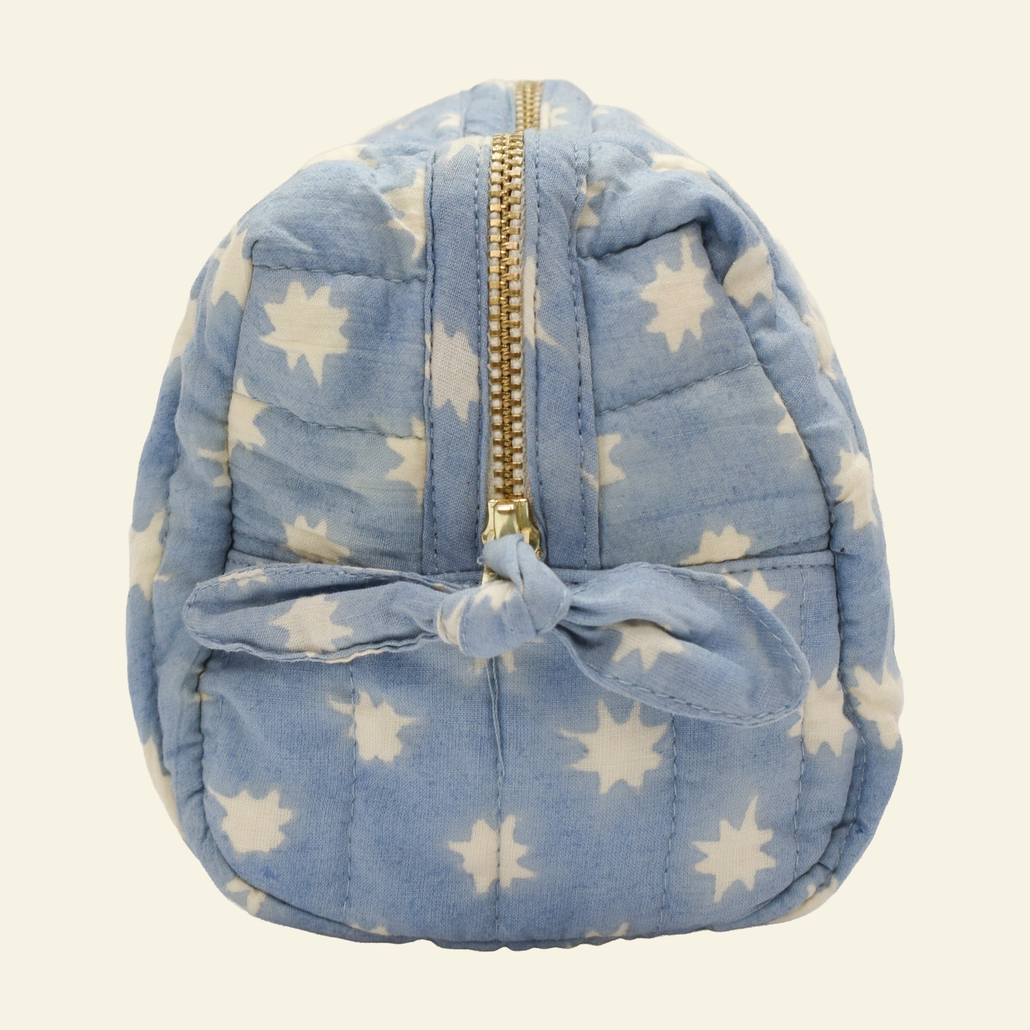 Close-up of Yonder sky blue Cosmic Loaf wash bag, quilted organic cotton with brass zip, hand block-printed in Jaipur