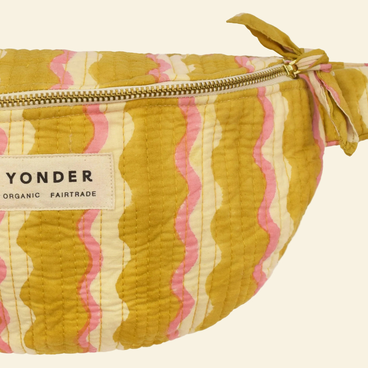 Close-up of Yonder honey wiggle bum bag, quilted organic cotton with brass zip, hand block-printed