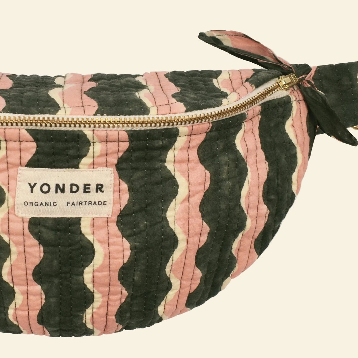 Close-up of Yonder fern-green whirly bum bag, quilted organic cotton with brass zip, hand block-printed