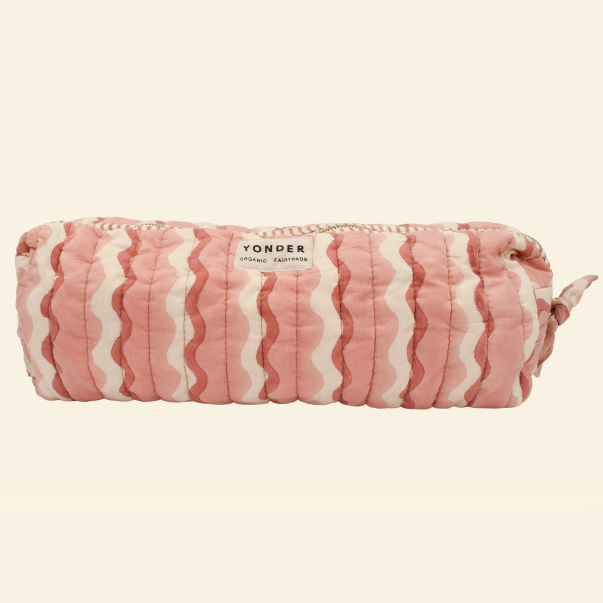 Yonder large organic cotton quilted wash bag in soft blush and cream wavy stripe print, with brass zip and side handle, hand block-printed in Jaipur