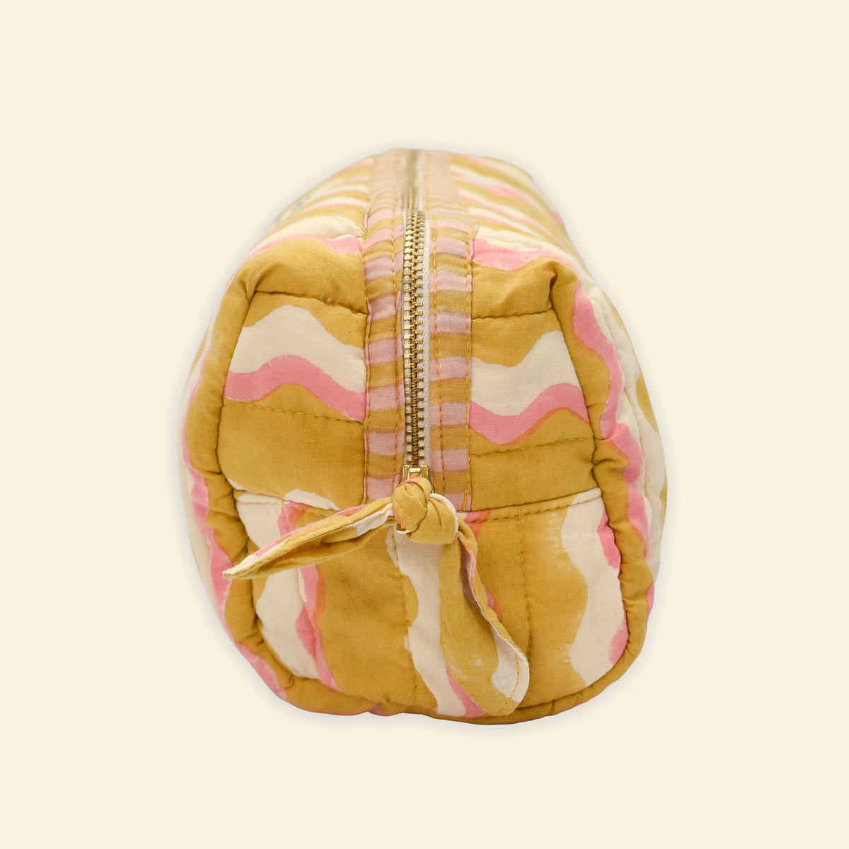 Yonder organic cotton quilted wash bag in golden honey wavy stripe print, side view, hand block-printed in Jaipur