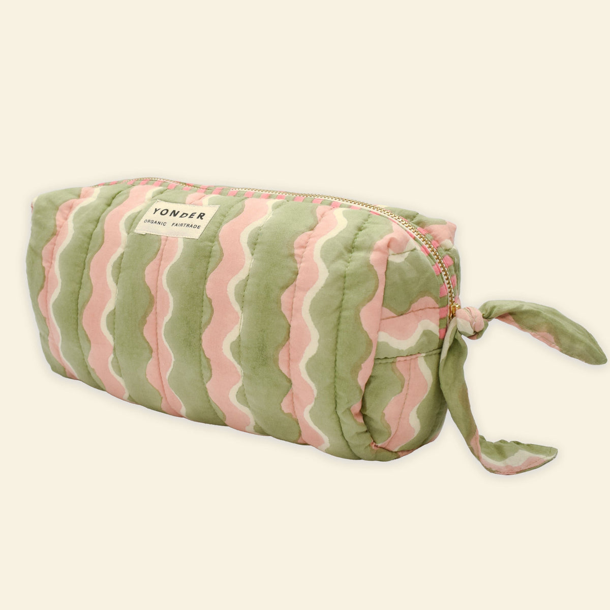Yonder organic cotton quilted wash bag in soft mint and pink swirling wave print, with brass zip and side handle, hand block-printed in Jaipur