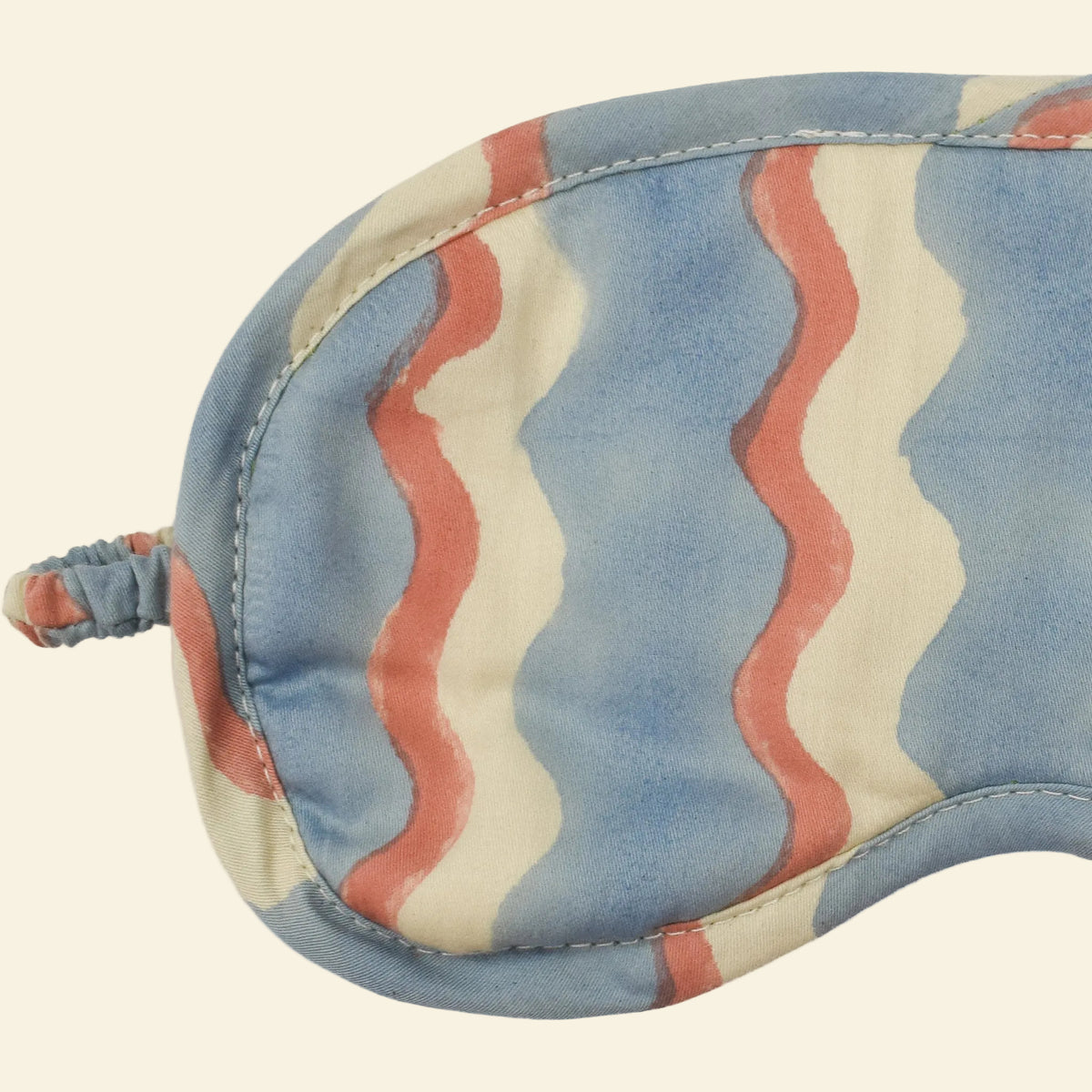 Close-up of Yonder Sky eye mask showing the blue and cream hand block-printed wave-stripe