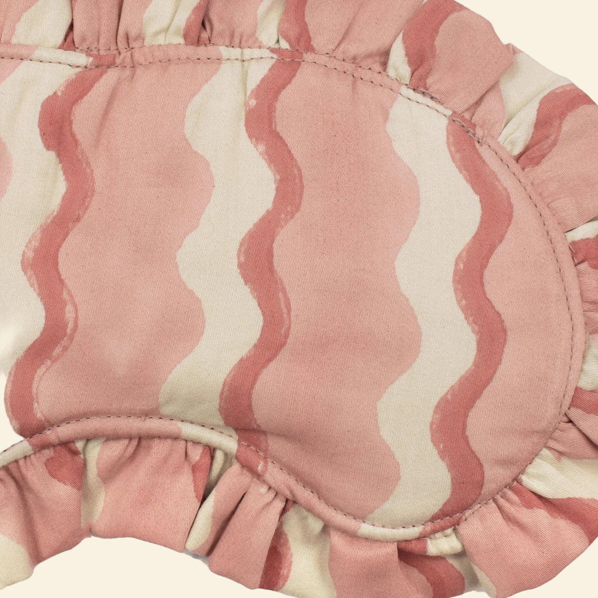 Close-up of Yonder Floss frill eye mask showing the pink and cream hand block-printed wave-stripe