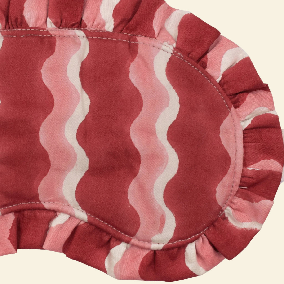 Close-up of Yonder Jam frill eye mask showing the red and pink hand block-printed wave-stripe