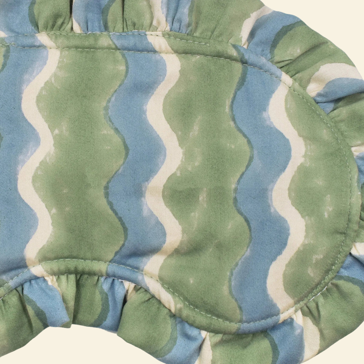 Close-up of Yonder Sage frill eye mask showing the green and blue hand block-printed wave-stripe