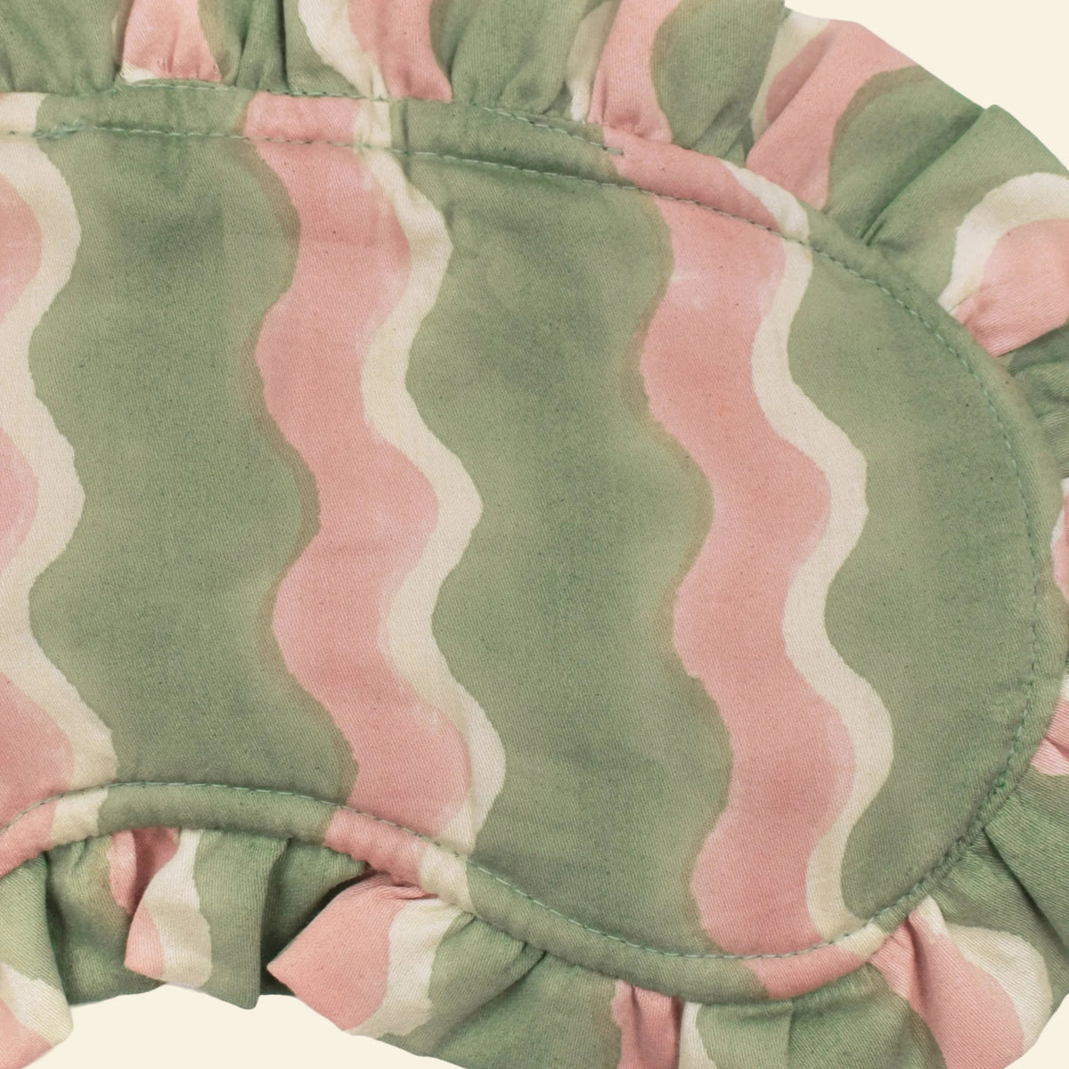 Close-up of Yonder Mint frill eye mask showing the green and pink hand block-printed wave-stripe