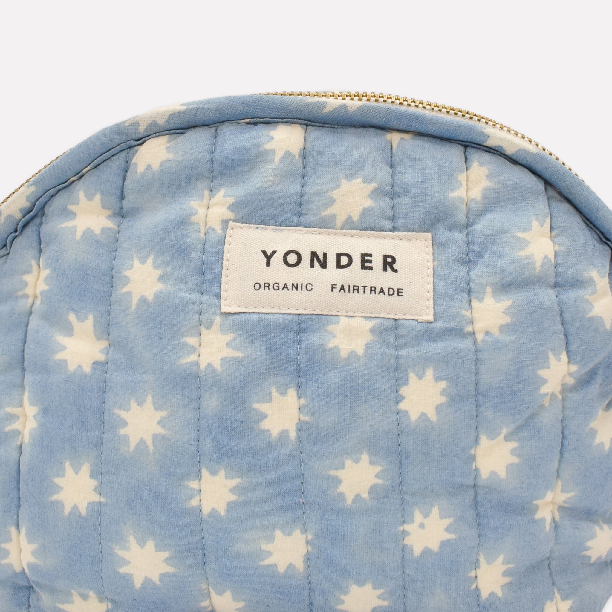 Closeup of cotton quilted zip pouch printed with blue star pattern