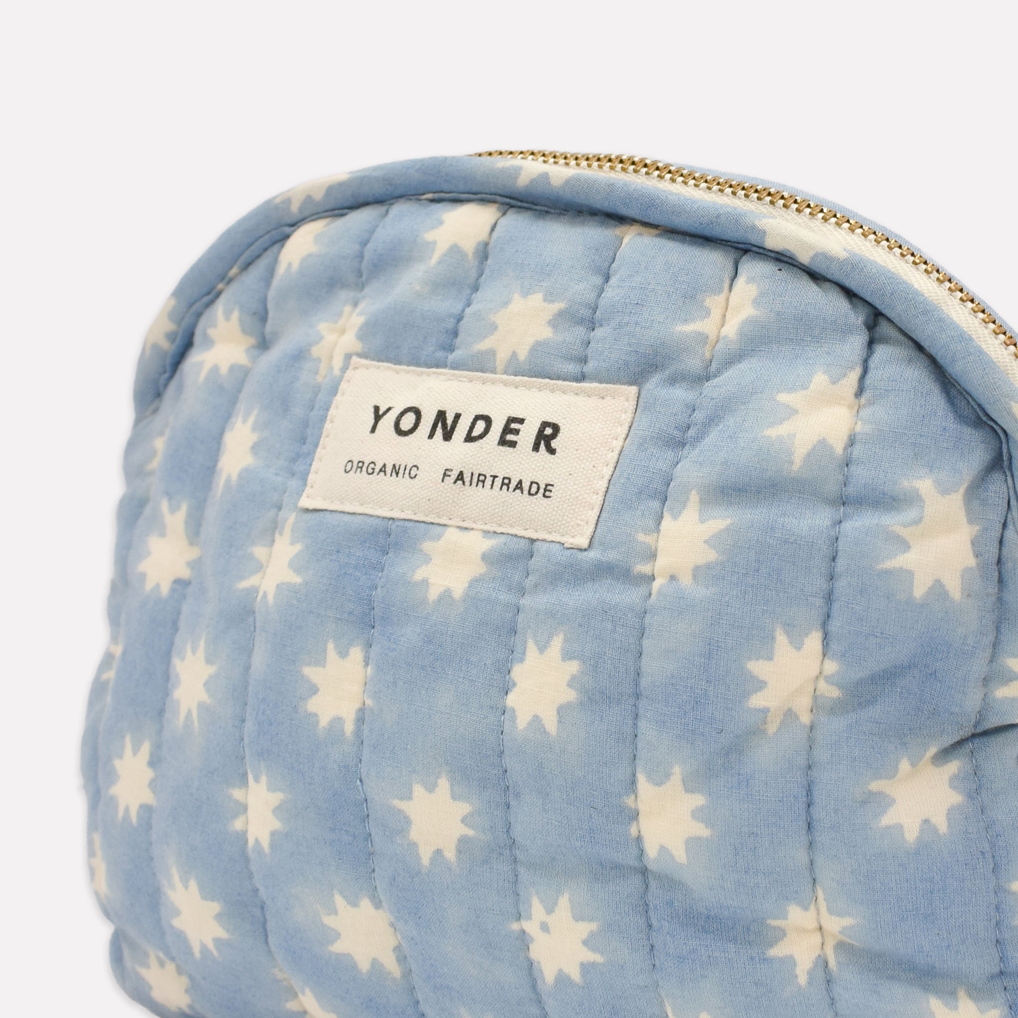 Closeup of cotton quilted zip pouch printed with light blue and white star pattern
