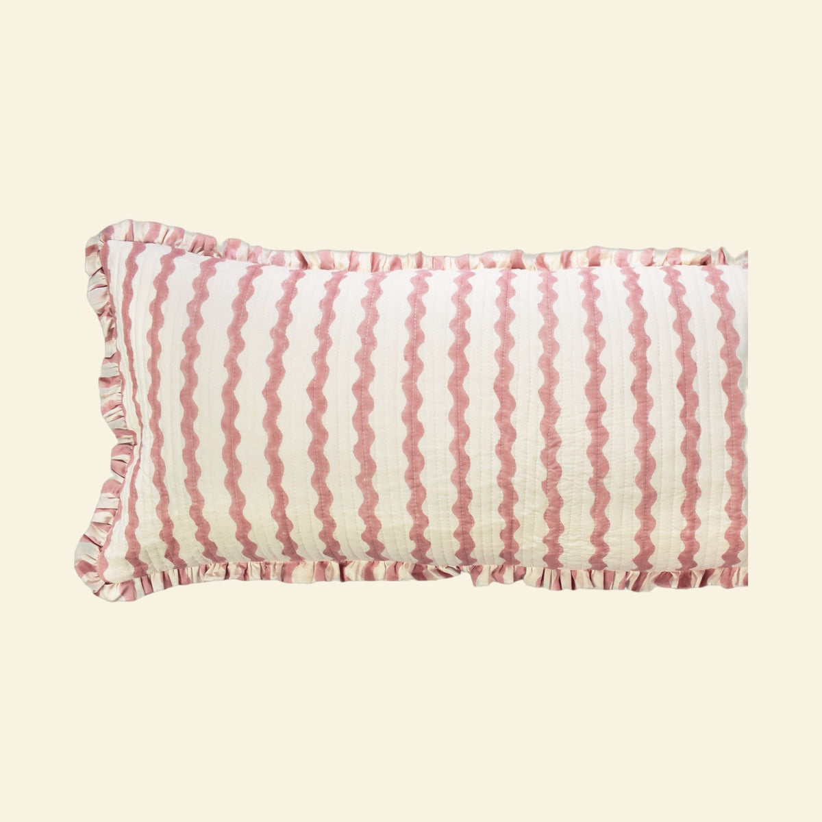 Close-up of Yonder Living Ripple ice cream bolster quilted frill cushion, soft rose block-printed ripple and frilled edge