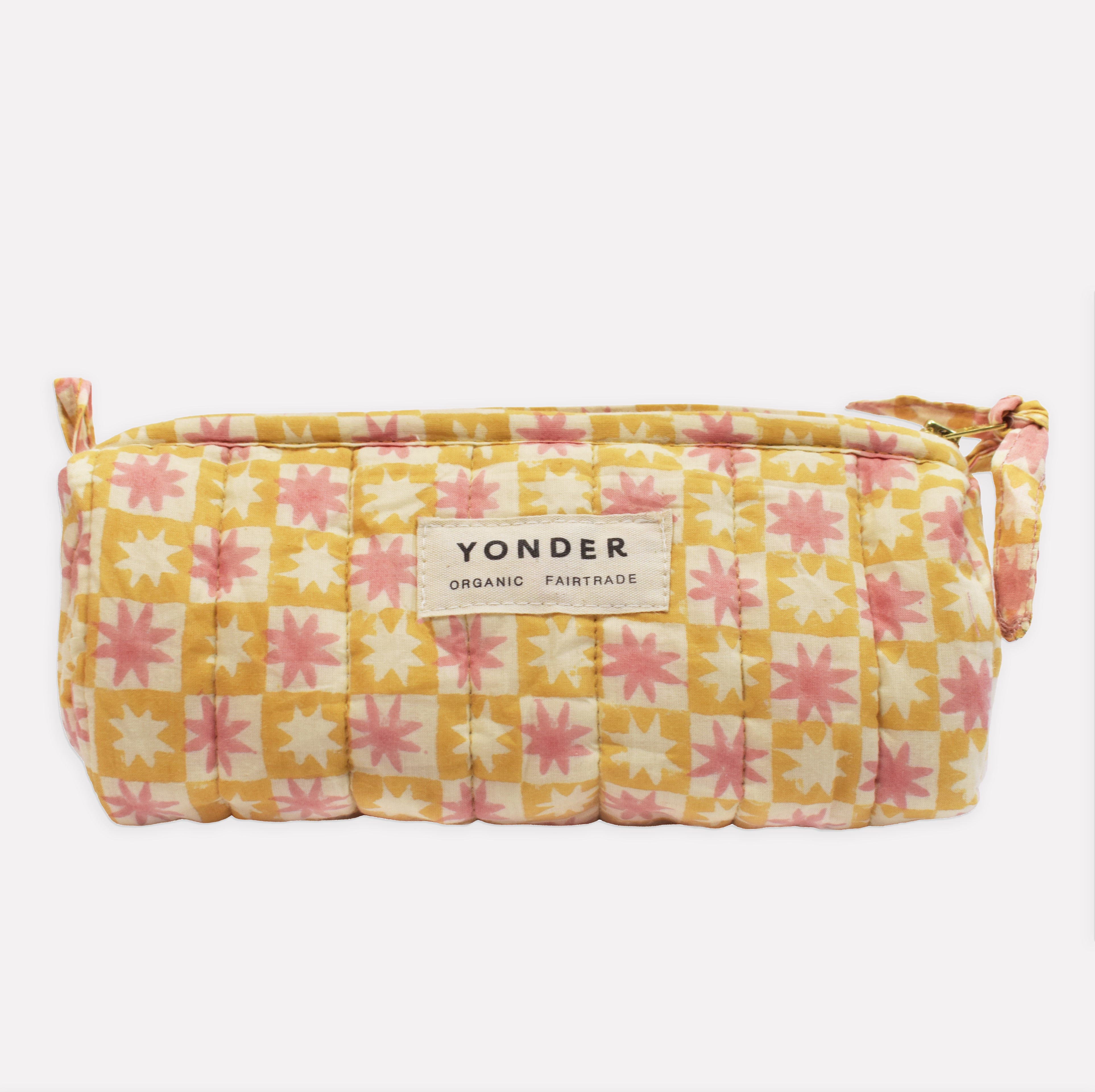 Yonder soft organic cotton brioche wash bag in lemon and white pinwheel star print with brass zip, hand block-printed in Jaipur