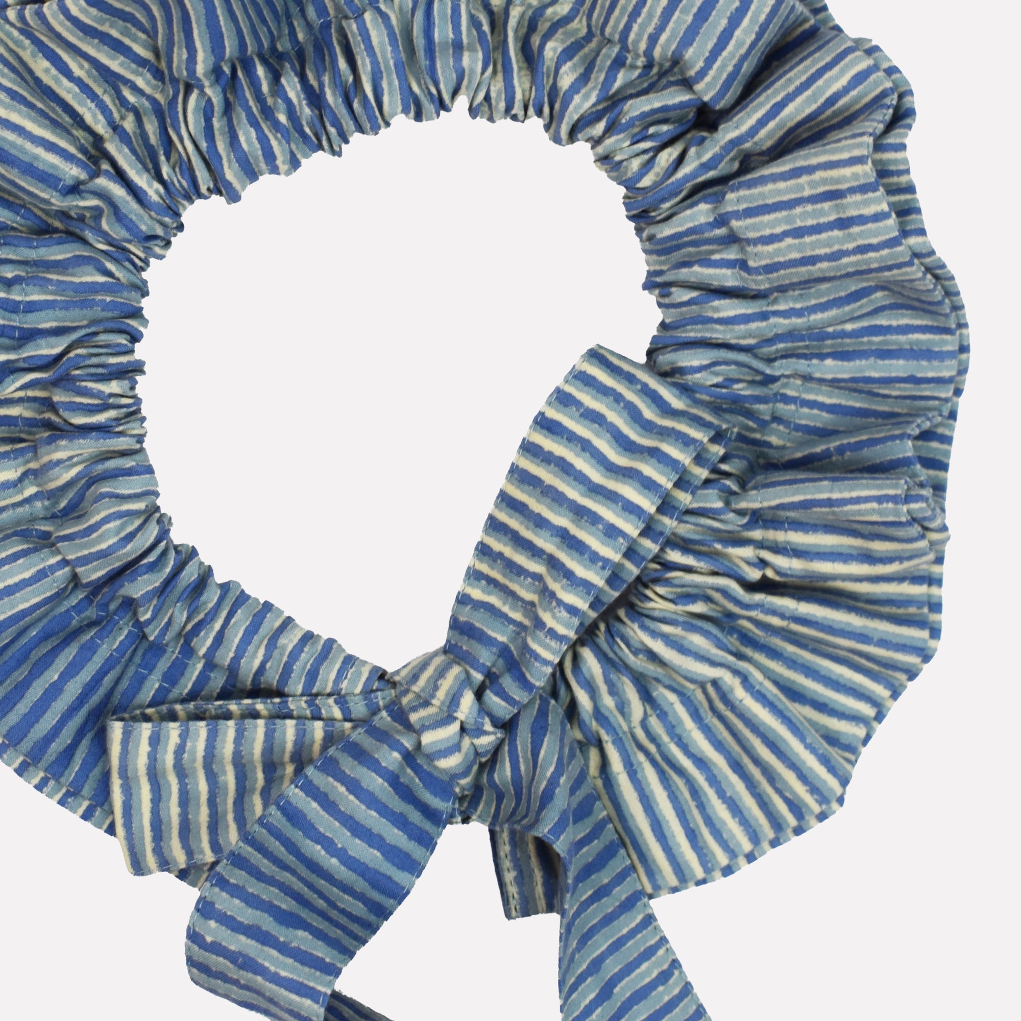 Closeup of cotton tie collar/scrunchie with ribbons printed with blue striped pattern