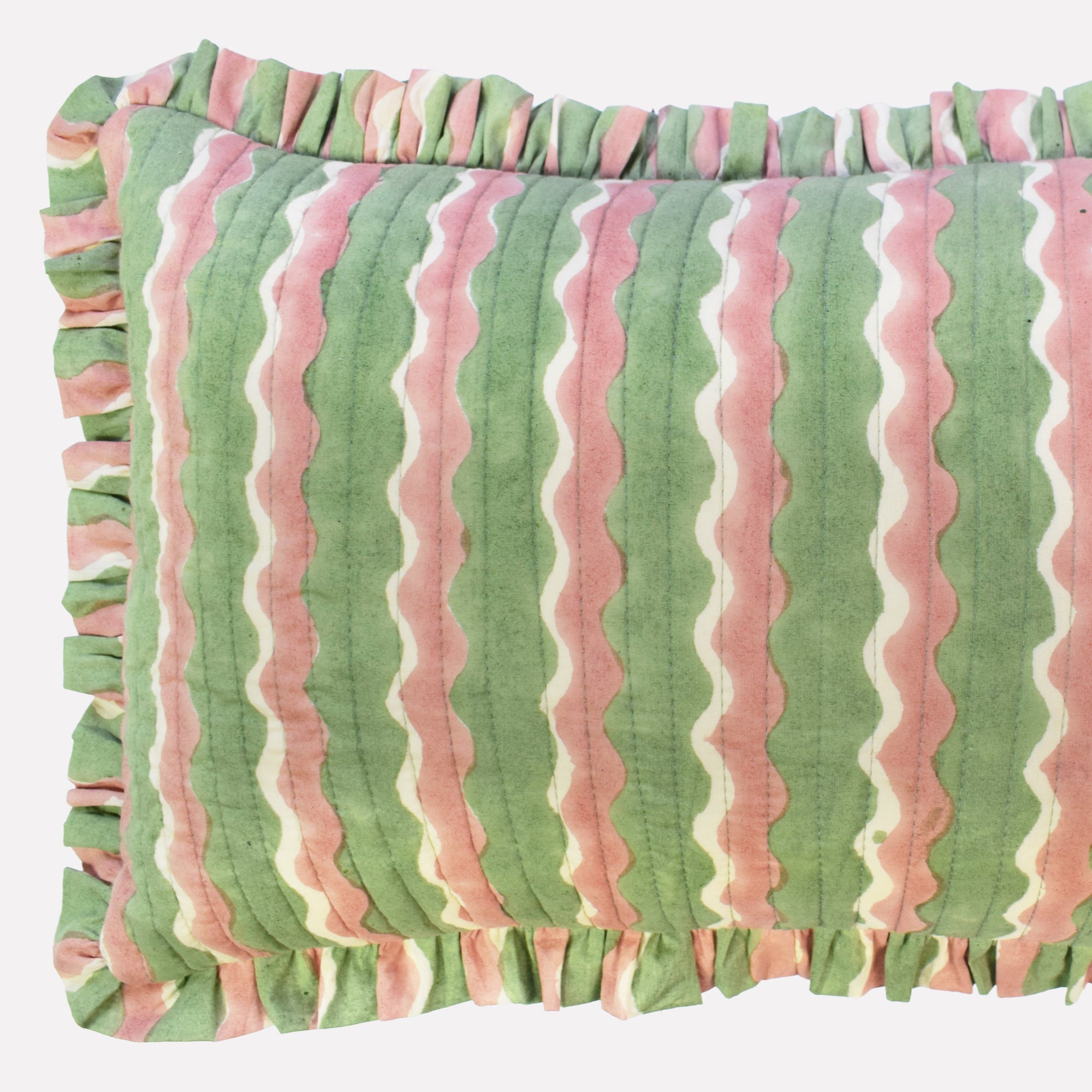 Closeup of cotton quilted cushion printed with green and pink striped wave pattern and frill border