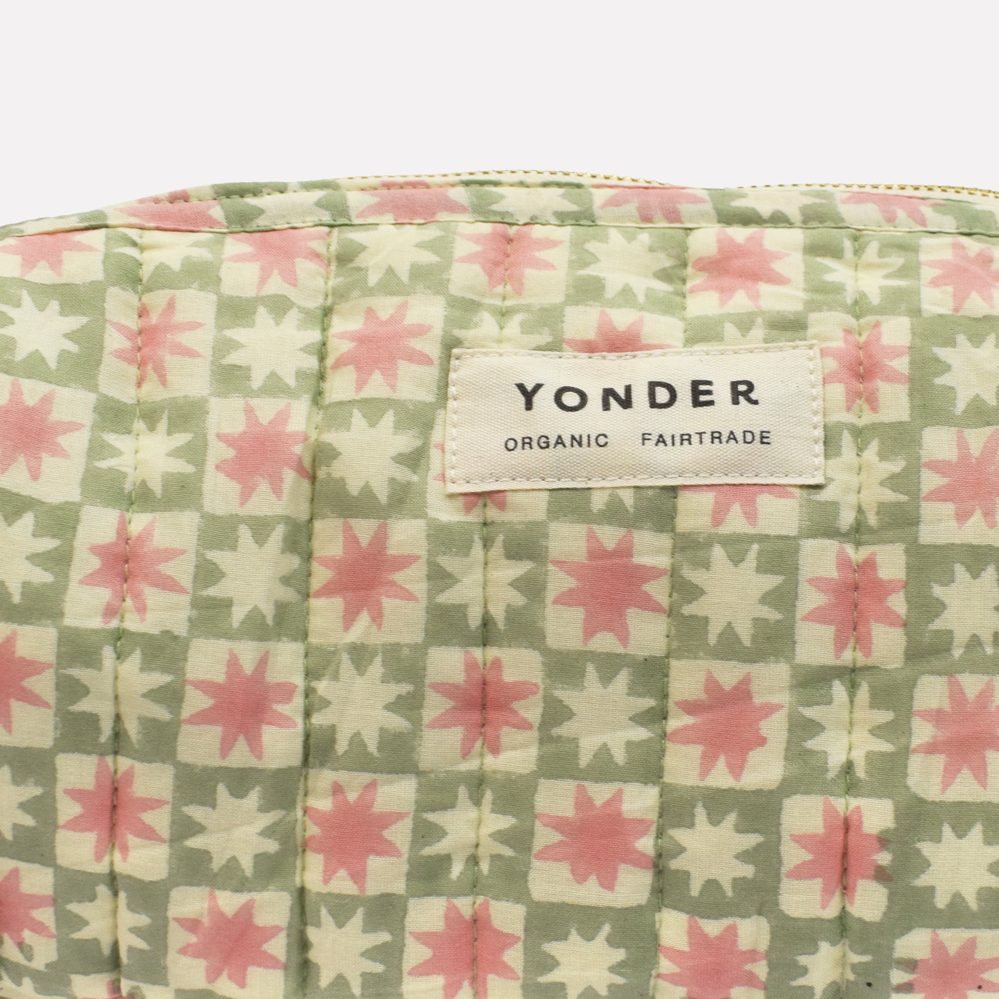 Closeup of cotton quilted wash/toiletry bag printed with green, pink, and white star pattern