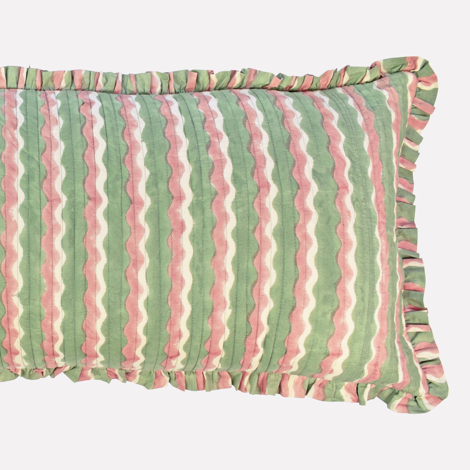 Closeup of long cotton quilted cushion printed with green and pink striped wave pattern and frill border