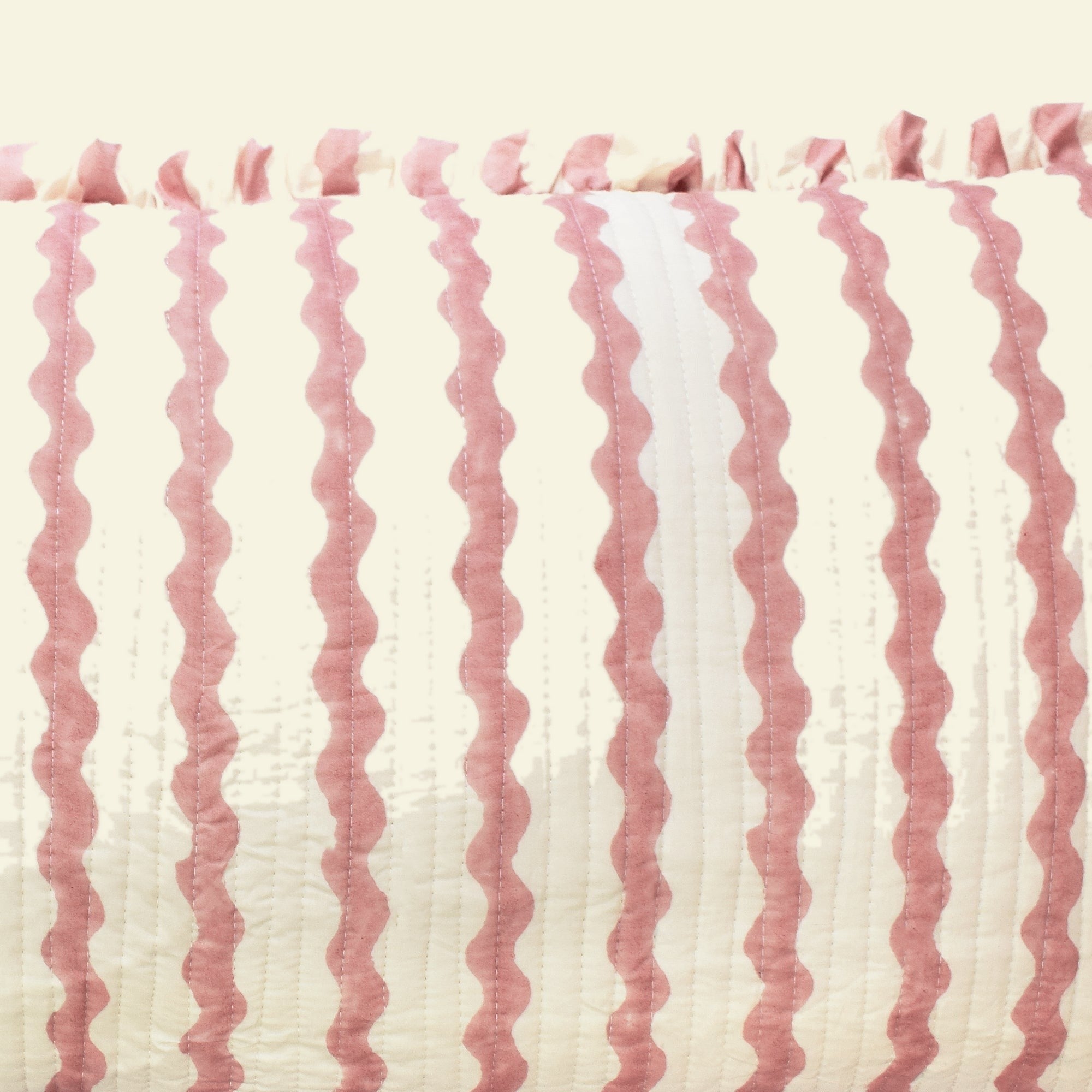 Close-up of Yonder Living Ripple ice cream quilted frill cushion, soft rose block-printed ripple and frilled edge