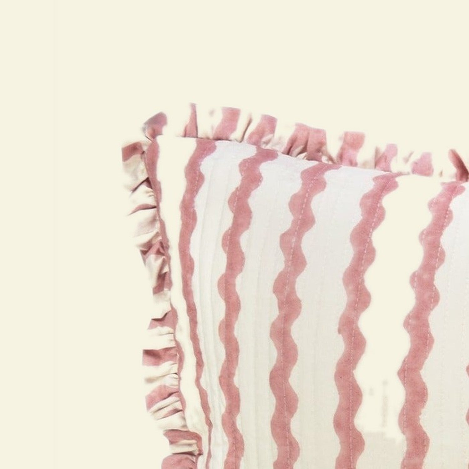 Close-up of Yonder Living Ripple ice cream bolster quilted frill cushion, soft rose block-printed ripple and frilled edge
